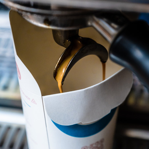 Photo d’un gobelet Aqueous en papier avec couvercle pliable et bec verseur intégré, solution écologique pour coffee shop et glacier.